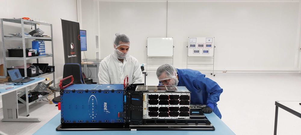 Two engineers integrating satellites on a ride-share dispenser