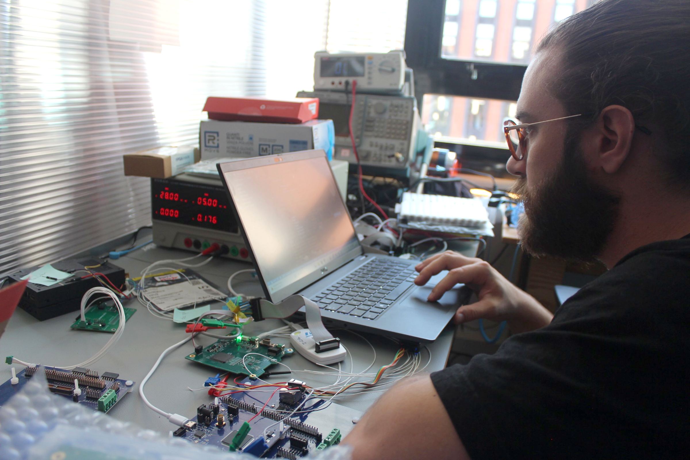 A SpaceLocker engineer testing electronics on a bench
