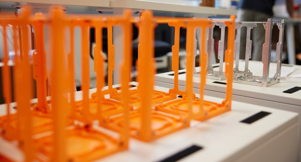 Orange 3D-printed and aluminium frames side by side