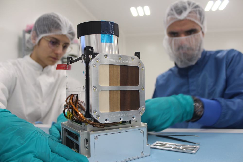 Engineers preparing a payload in a clean room