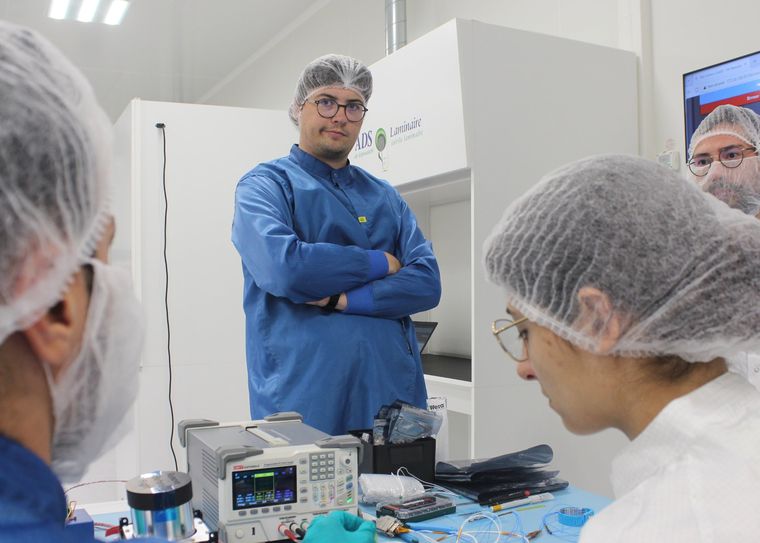 Engineers testing a payload on a bench in a clean room