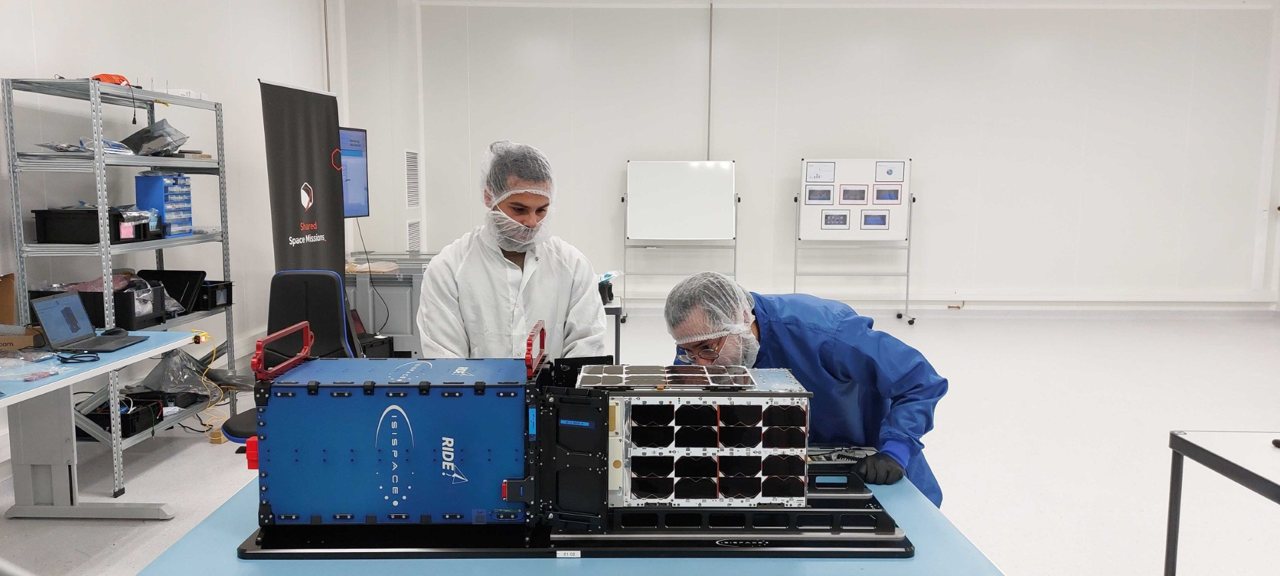 Engineers integrating the Out of the Box satellite in a clean room
