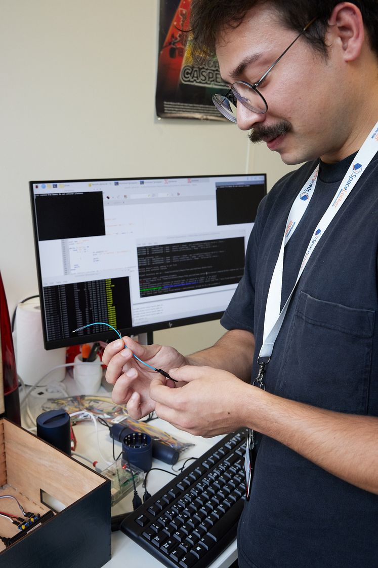 A SpaceLocker engineer preparing a cable at his desk