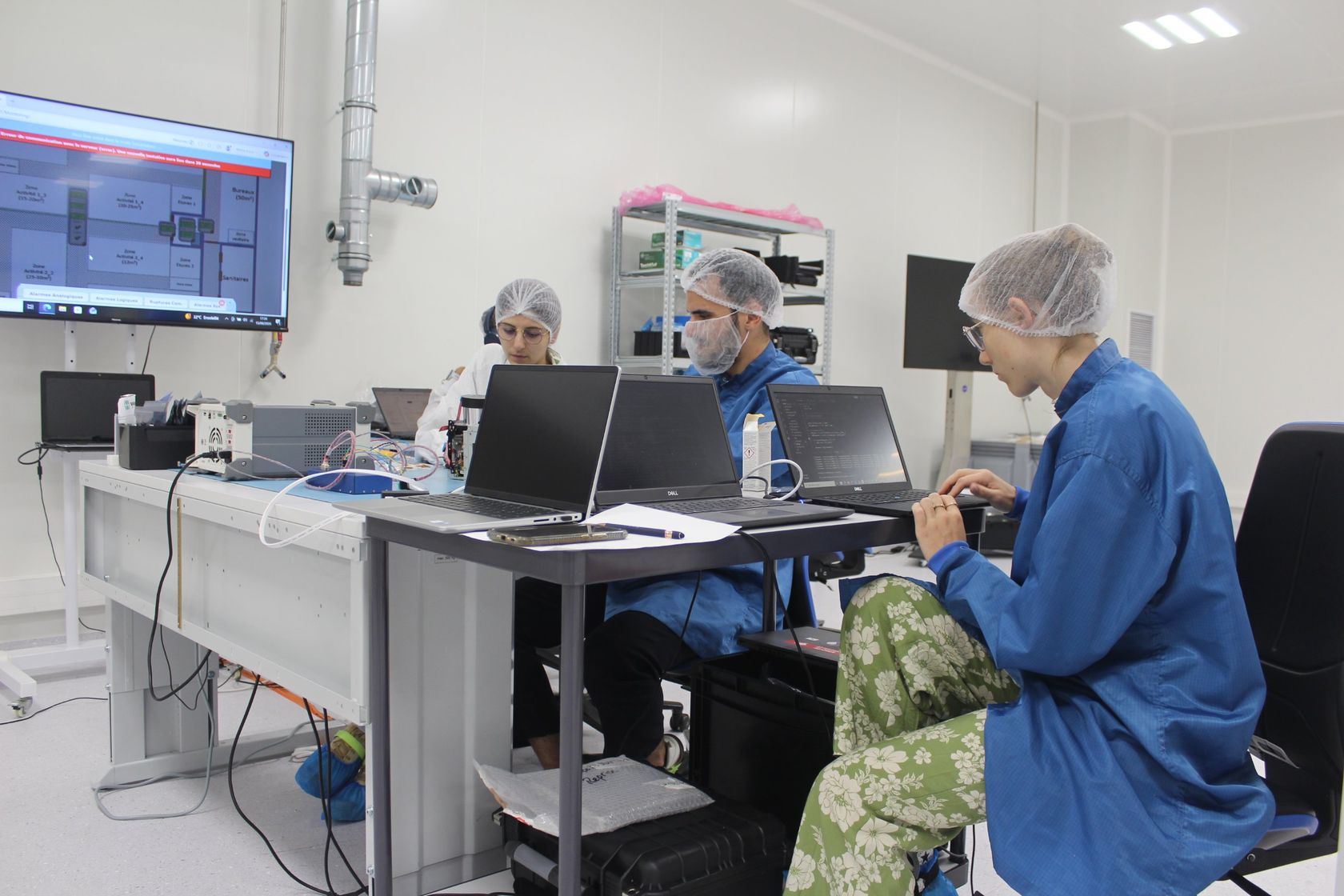 Engineers running tests on laptops in the clean room