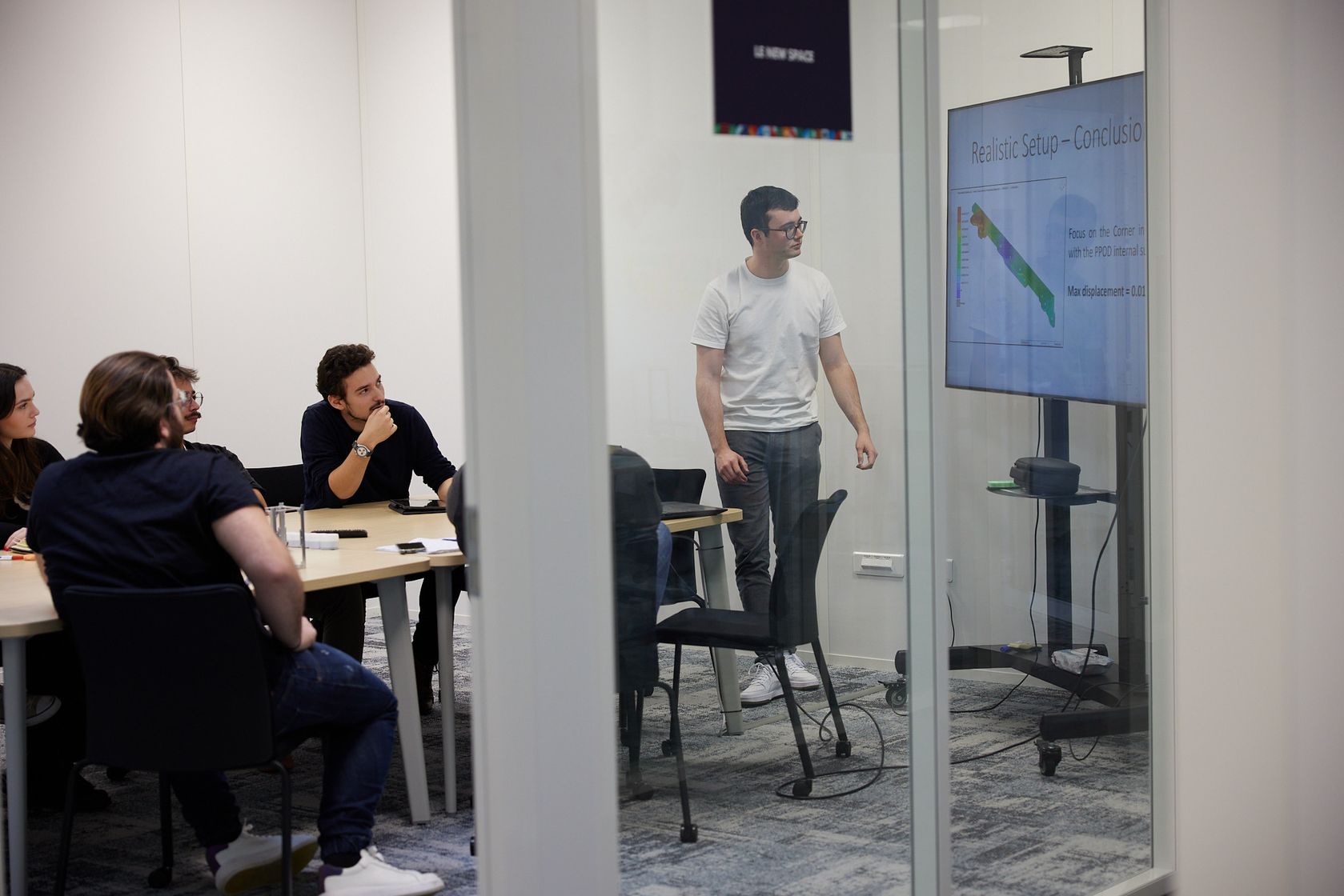 An engineer presenting simulation results to the team